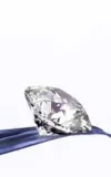 A polished diamond on blue fabric