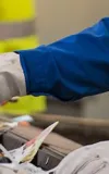 People in yellow safety vests wearing gloves while picking through trash