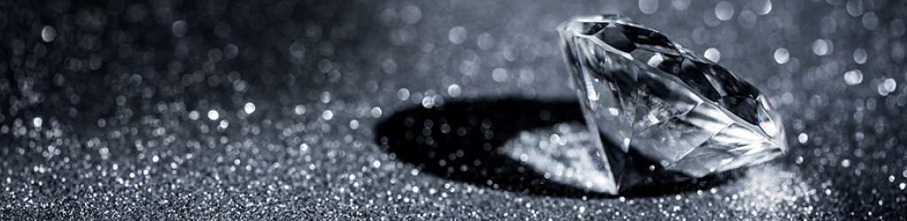 A polished diamond on a sparkly black background