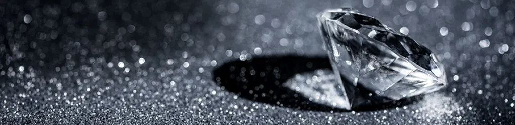 A polished diamond on a sparkly black background